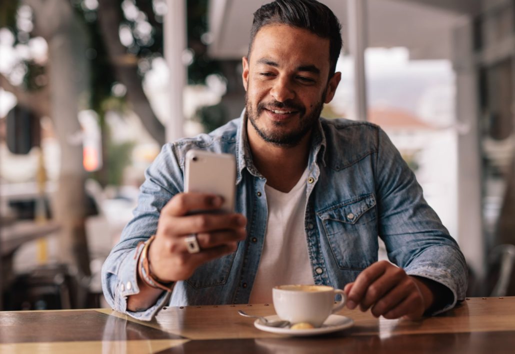 Man receiving a text message promotion during morning coffee